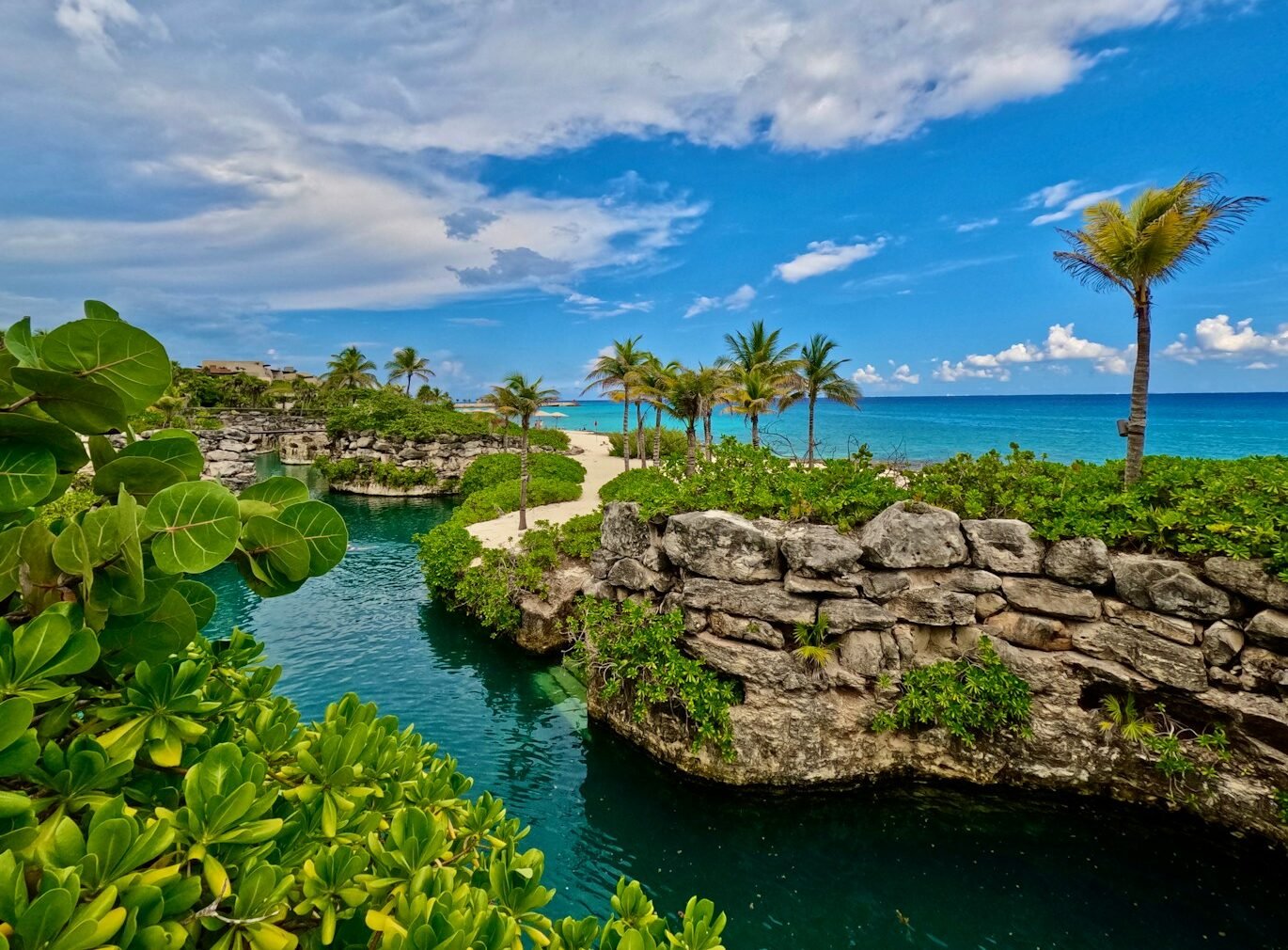 xcaret a river running through a lush green forest next to the ocean