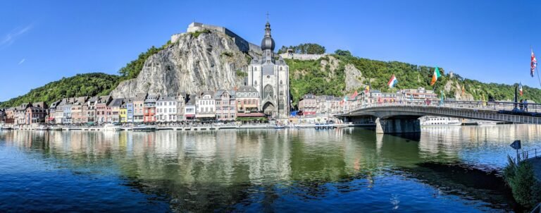 belgium tours grey concrete buildings beside calm body of water