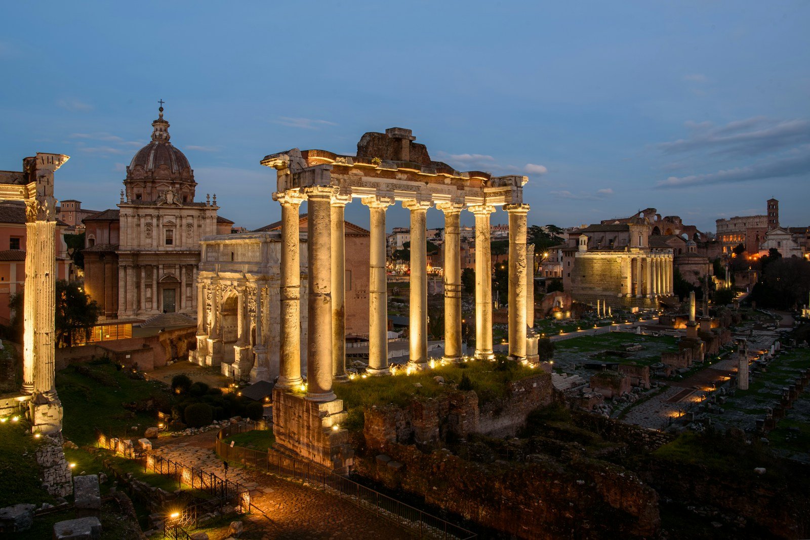 the ruins of a roman city lit up at night roman forum travel guide
