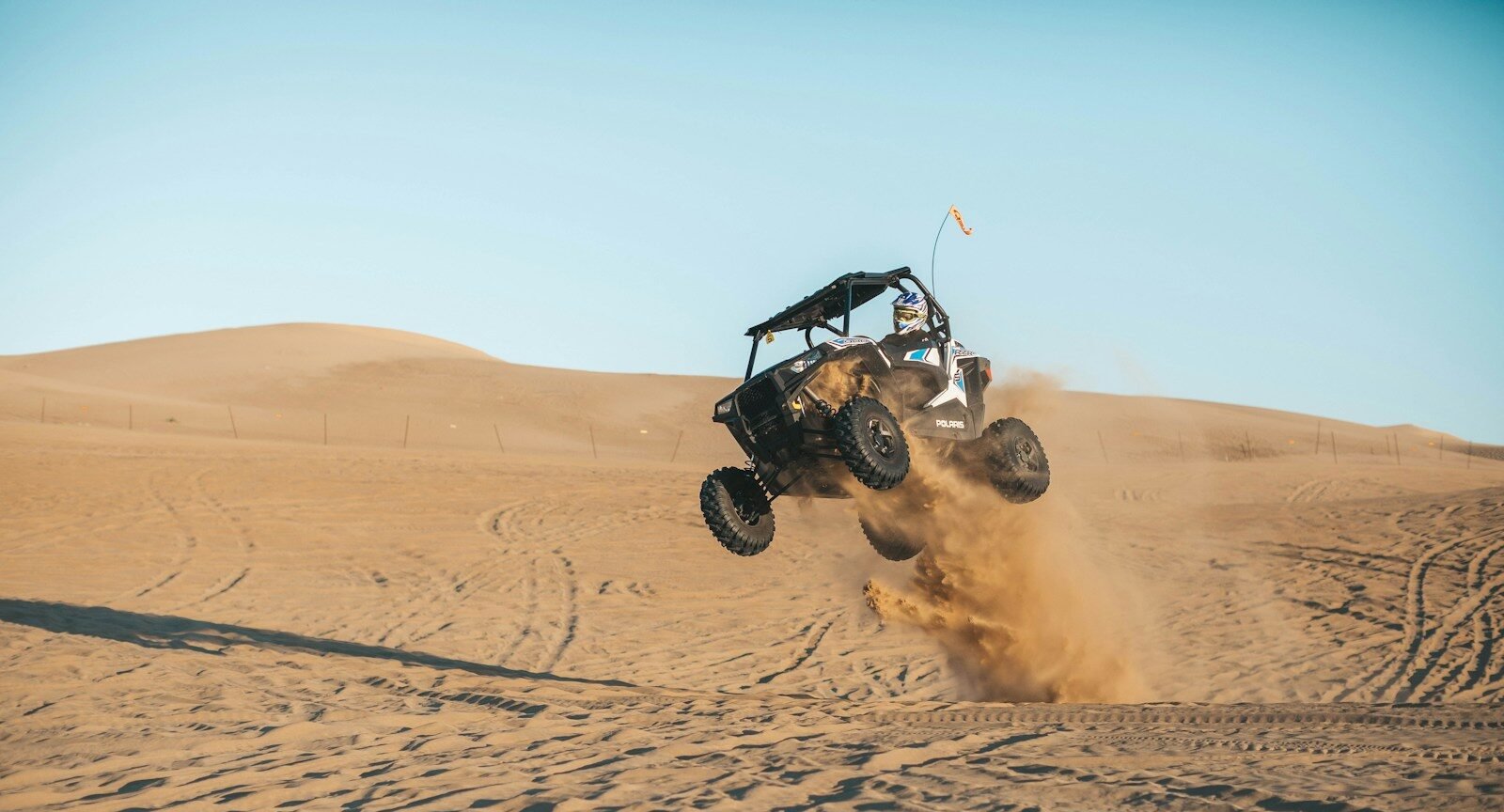 adrenaline man riding on UTV on desert during daytime