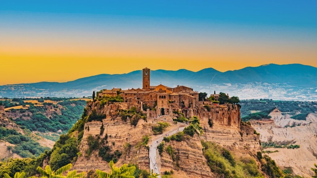 Civita di Bagnoregio, Bagnoregio, Italia a castle on top of a mountain surrounded by trees