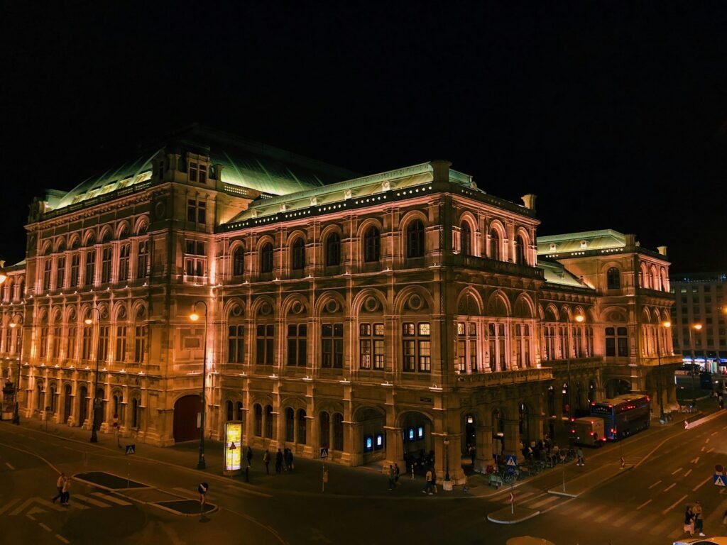 Vienna, Austria people walking on street near brown concrete building during night time
