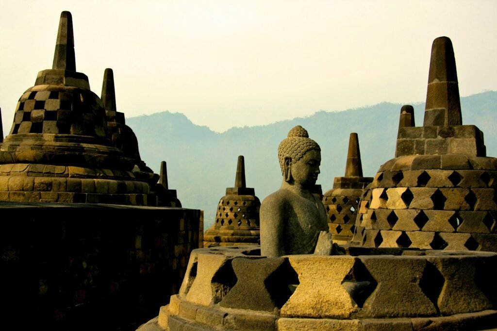 indonesia travel guide gold buddha statue on top of white and brown concrete building during daytime