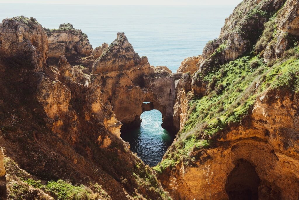 Algarve, Portugal brown rock formation near body of water during daytime