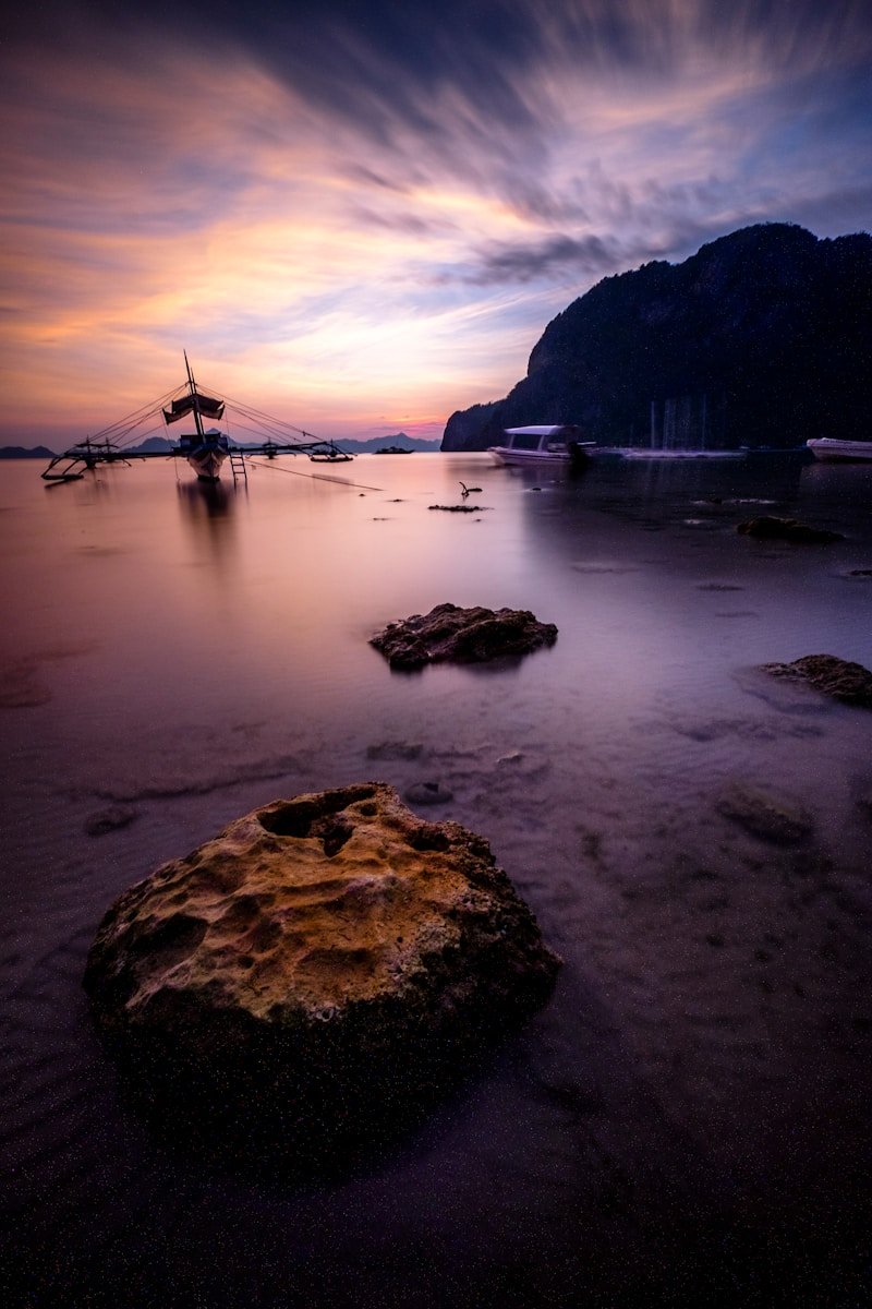 ASIA TOUR TRAVEL GUIDE boat near boulders and hills
