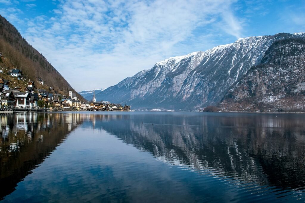 Hallstatt, Austria body of water near mountain under blue sky during daytime