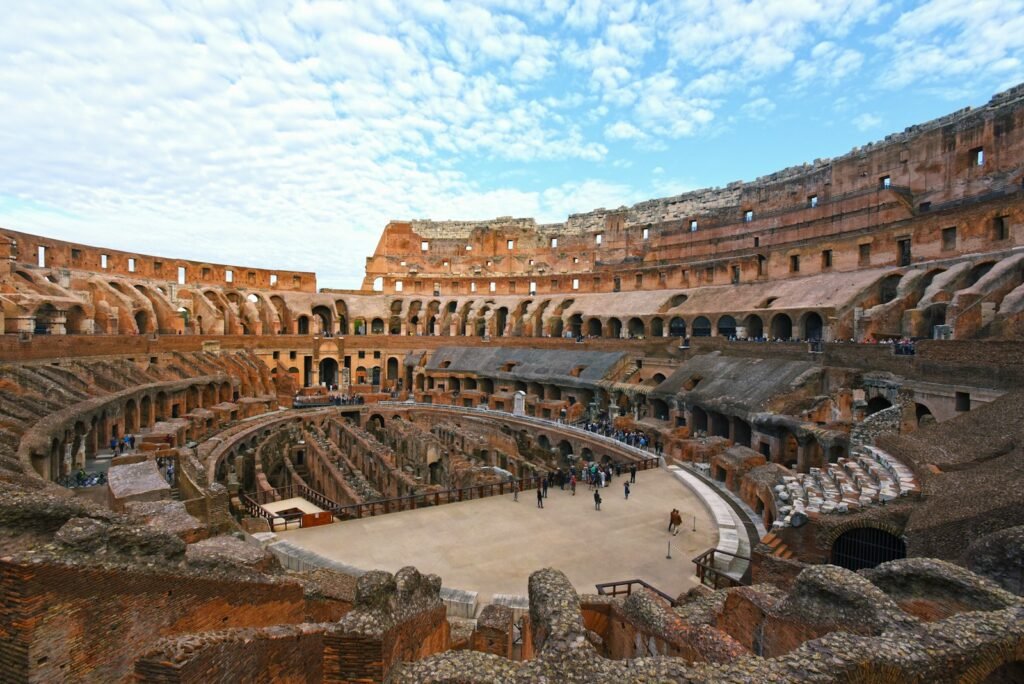 colosseum people walking on brown concrete bridge during daytime