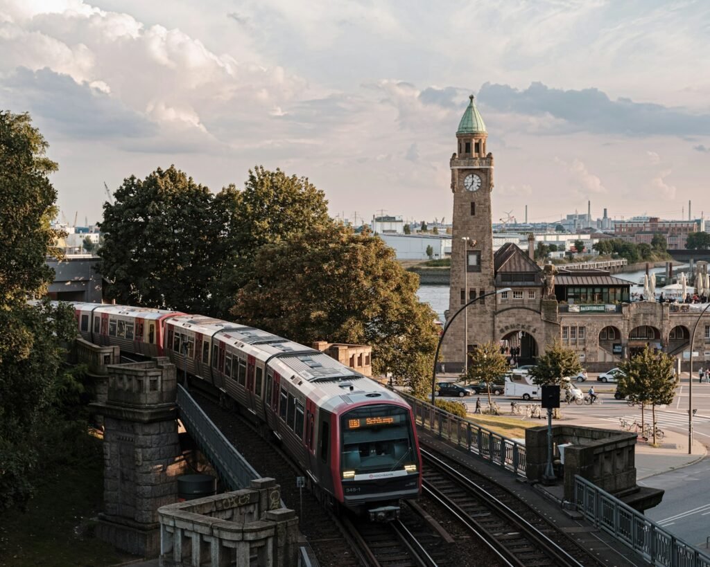 Hamburg, Germany brown and white train on rail road near brown concrete building during daytime