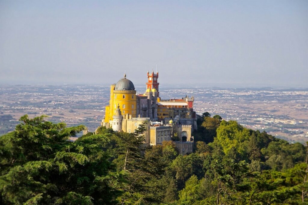 Pena Palace, Portugal gray and yellow castle at the top of a hill